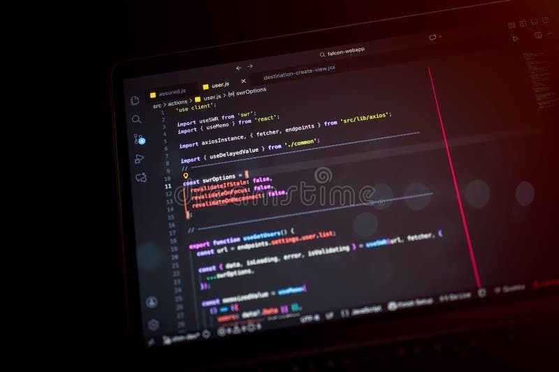 Nahaufnahme eines Laptops mit Code auf dunkel beleuchtetem Bildschirm