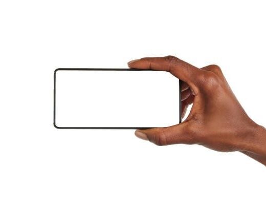 Eine Hand hält ein Smartphone im Querformat vor weißem Hintergrund